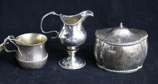 A silver tea caddy, silver cream jug and Indian silver mug.